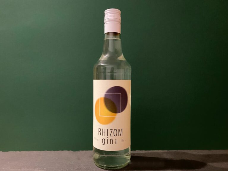 Eine durchsichtige Flasche Rhizom Gin mit weißem Verschluss, versehen mit einem modernen Etikett mit sich überlappenden gelben und violetten Kreisen vor einem dunkelgrünen Hintergrund.