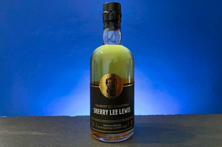 Eine Flasche „Sherry Lee Lewis Single Cask Gin“ steht vor einem blauen Hintergrund; auf ihrem schwarz-goldenen Etikett ist ein markantes Wappen abgebildet.