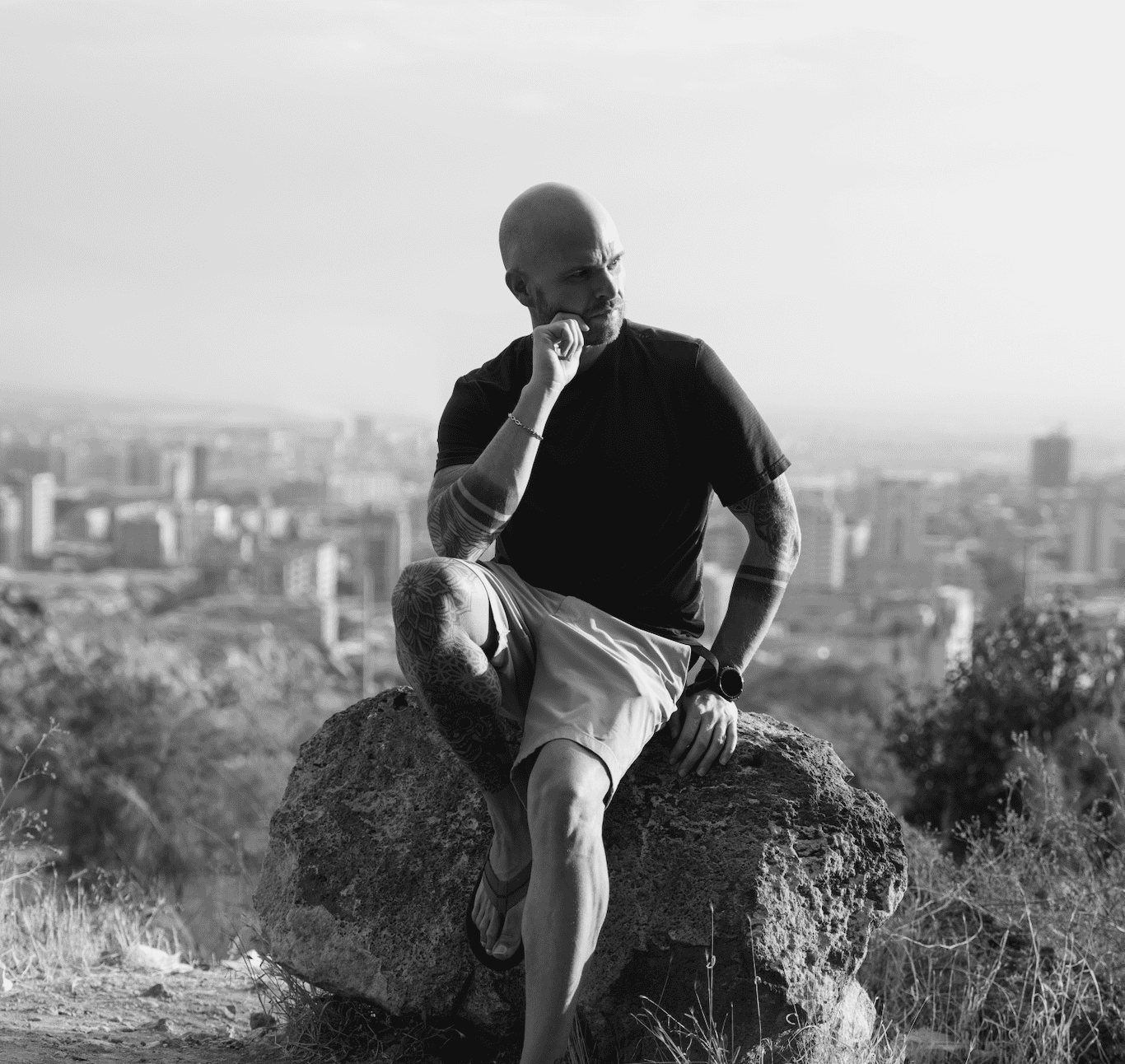 Maximilian Mende, Gründer und Autor des Gin Blogs Ginnatic, sitzt auf einem Felsen mit Blick über die Stadt